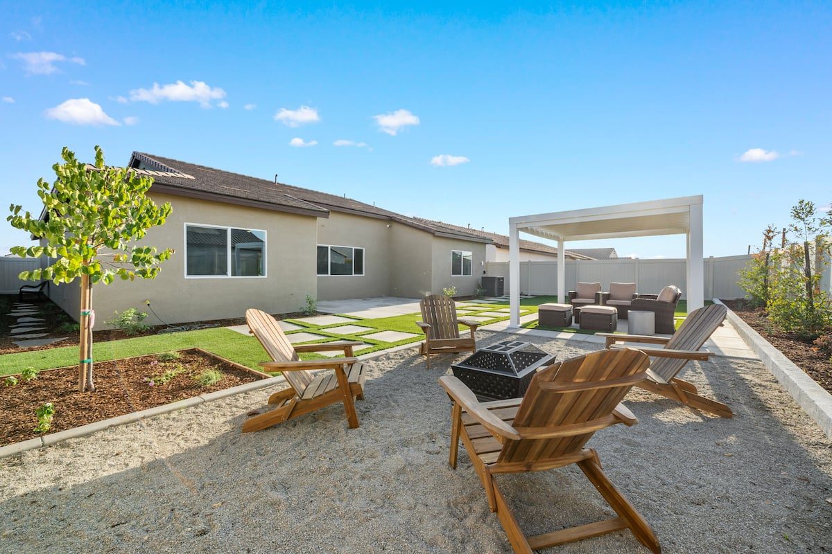 Backyard with a fire pit, lounge chairs and a covered patio